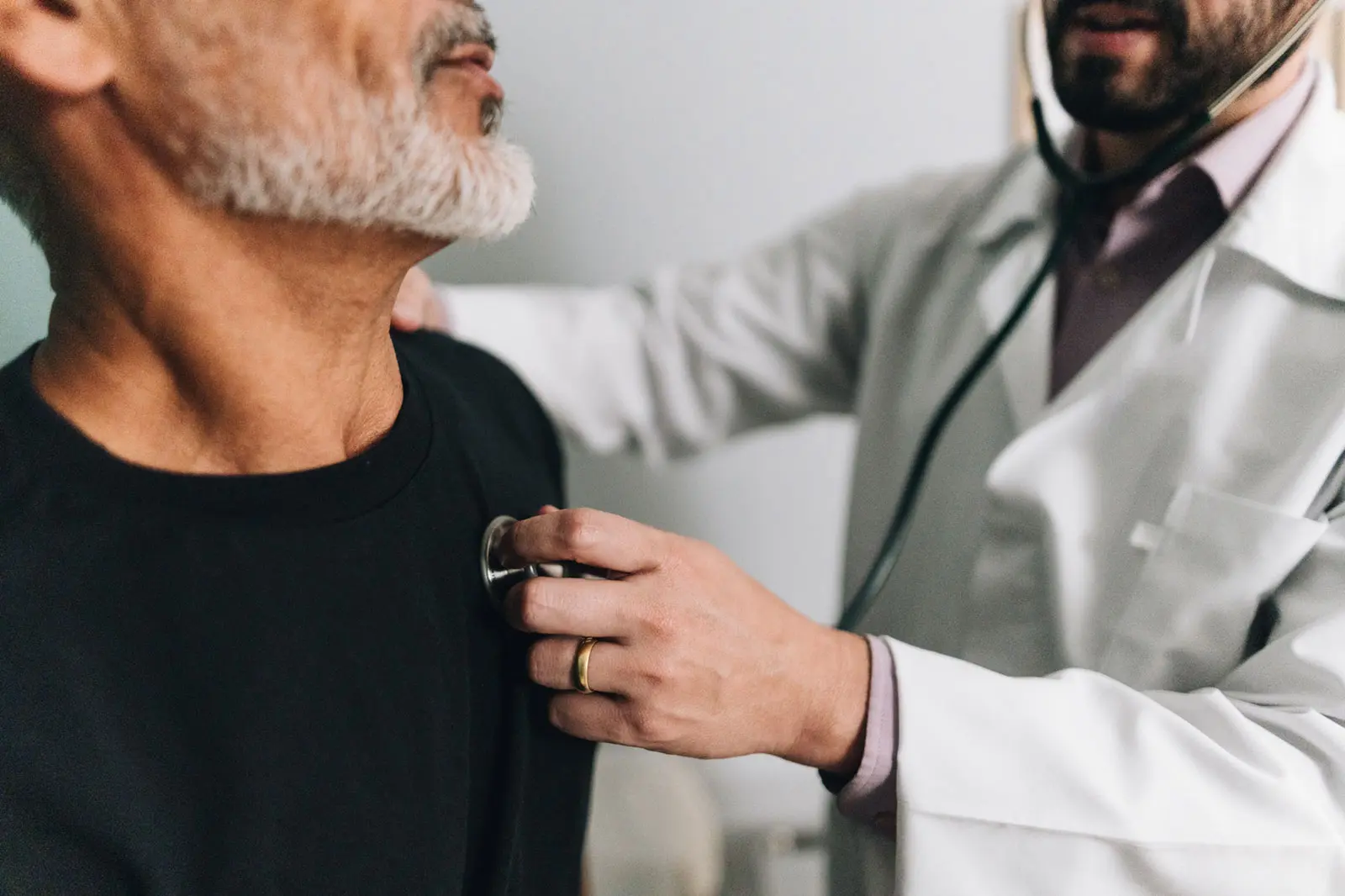 A cardiologist listening to a patient's heart with a stethoscope during an examination