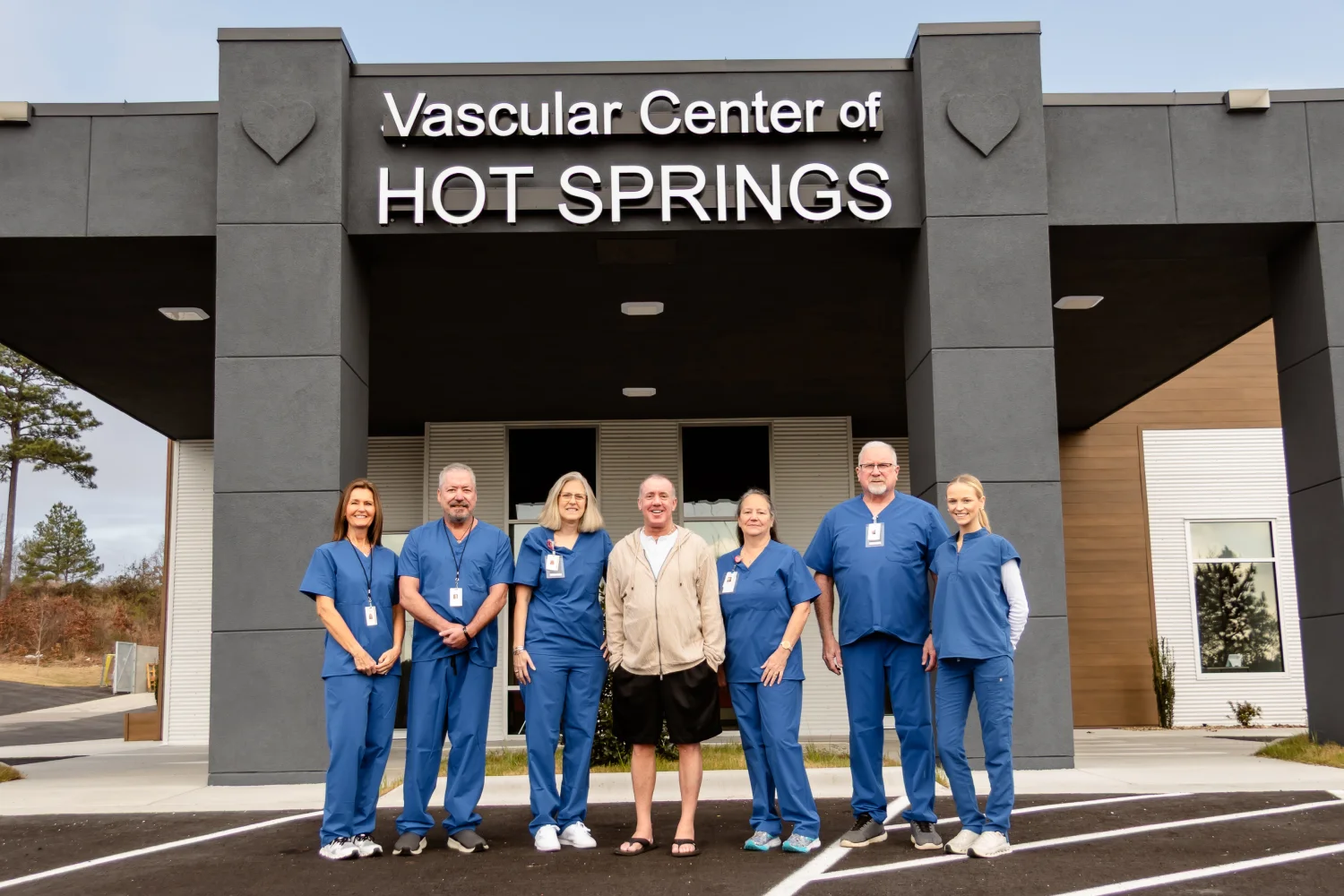 Jeffrey G. Tauth, M.D., F.A.C.C., with his care team in blue scrubs outside the Vascular Center of Hot Springs